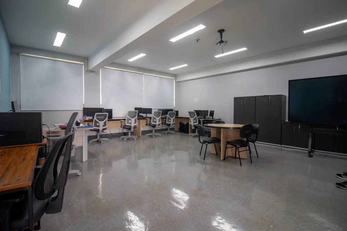 Laboratório de Pesquisa e Desenvolvimento com estações de trabalho, mesa de reunião e tela interativa